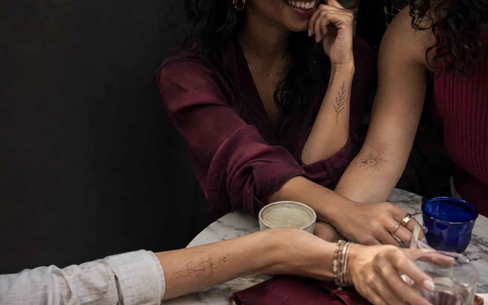 A group of friends wearing fine-line temporary tattoos